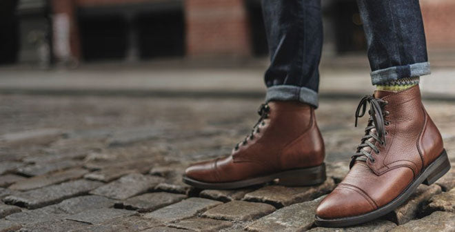 Botas de cuero marrón sobre adoquines